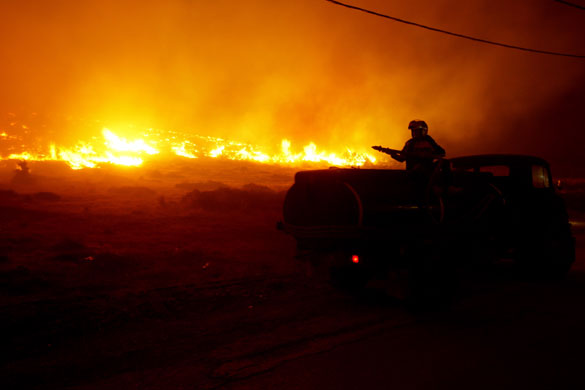 Fires in Greece: A resident on a water wagon during a fire at mount Penteli