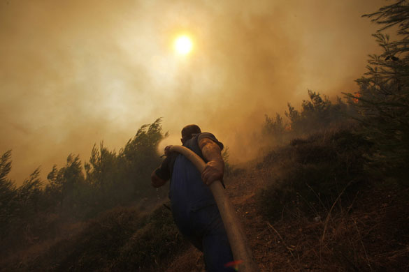 athens update: A firefighter battles with blazes in Pendeli Athens suburb