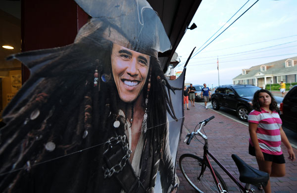 Obama holiday: People walk past a cut-out depicting Obama as the Pirate of the Caribbean