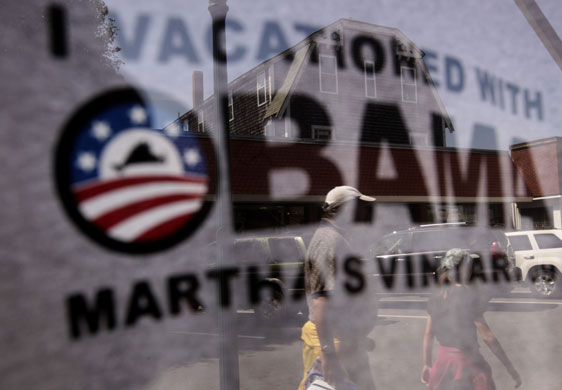 Obama holiday: Passers-by appear reflected in a store-front window in Oak Bluffs