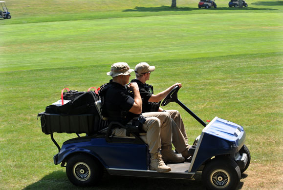Obama holiday: Two secret service agents follow in a cart as Barack Obama plays golf