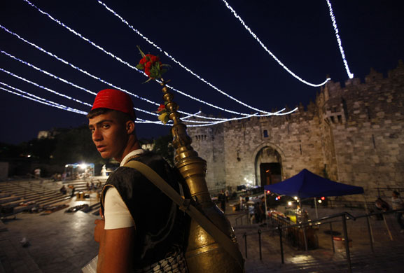 24 hours in pictures: A tea vendor stands under festive lights just outside Jerusalem's Old City
