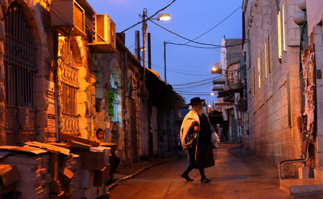 24 hours in pictures: Ultra-Orthodox Jewish man wearing a prayer shawl on his way to a synagogue
