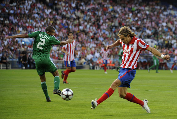 champions league : Diego Forlan slides the ball inside Bryce Moon