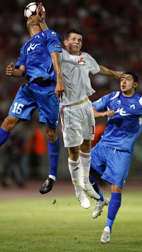 champions league: Chakib Benzoukane gets his head to the ball ahead of Gergely Rudolf