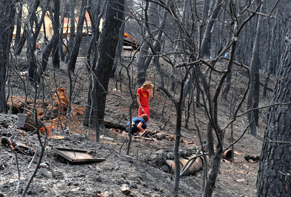 26 August 2009: Aghios Stafanos, Greece: Children react as they stand by a burnt bird