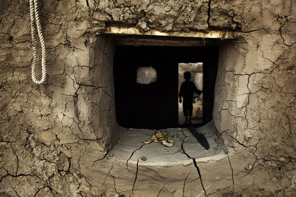 26 August 2009: Kabul, Afghanistan: A boy walks inside his home