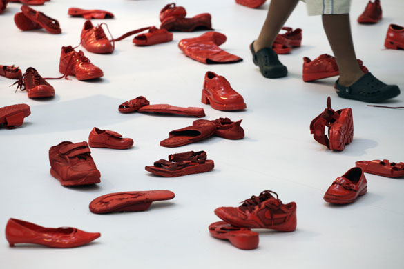26 August 2009: Hong Kong, China: A man walks past scattered red-painted shoes