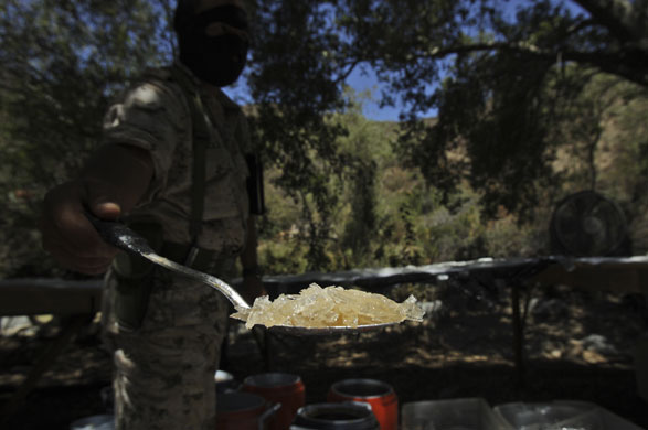 24 hours in pictures: Ensenada, Mexico: A soldier displays a spoon containing raw methamphetamine