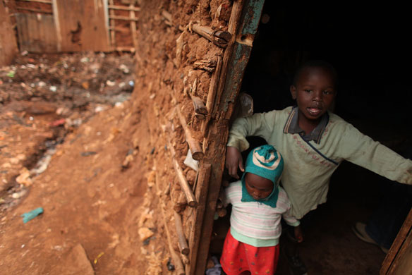 24 hours in pictures: Nairobi, Kenya: Children look out from their home in the Kibera slum