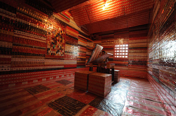 24 hours in pictures: Hangzhou, China: A man in his house, decorated with cigarette packets