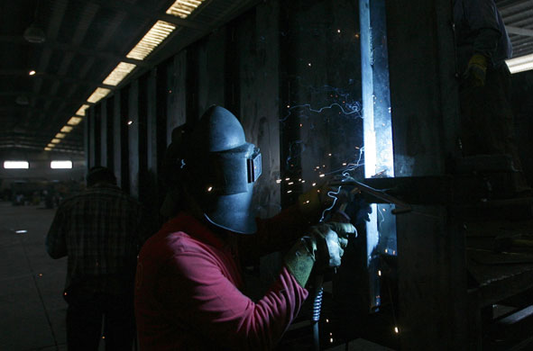 24 hours in pictures: Jenin, West Bank: A Palestinian worker welds a newly-made rubbish bin