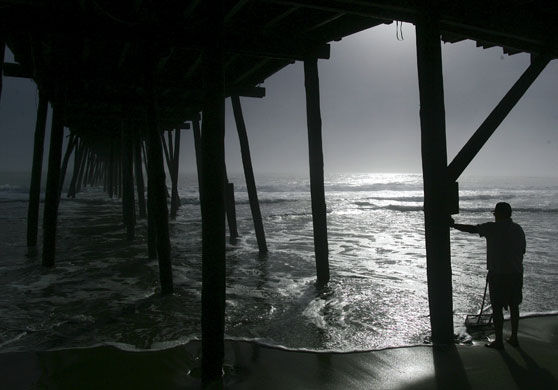 24 hours in pictures: Kitty Hawk, US: John Allen of Charlotte works the surf 