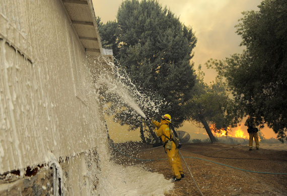 Los Angeles fire: A firefighter sprays foam on a house