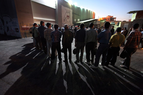 24 hours in pictures : Palestinians wait to cross separation barrier for work 
