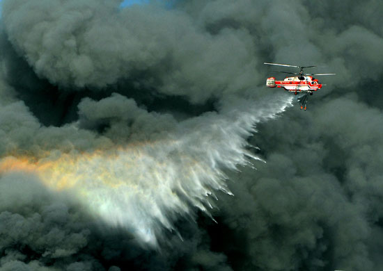 5 August 2009: Pyeongtaek, South Korea: A helicopter releases water to extinguish a fire