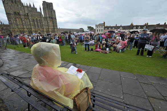 Harry Patch funeral: A woman sits alone outside Wells Cathedral during Harry Patch's funeral 