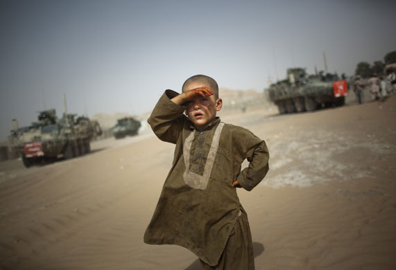 7 August 2009: Spin Boldak, Afghanistan: A child watches military vehicles drive past his village