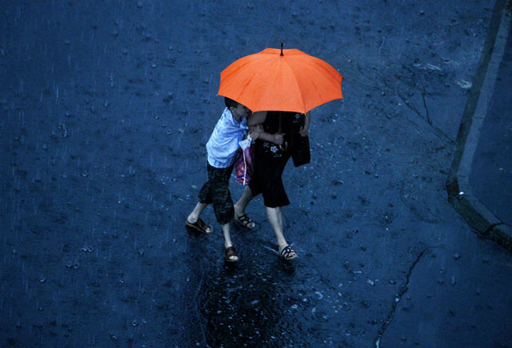 7 August 2009: Bucharest, Romania: A woman and child cross a flooded street