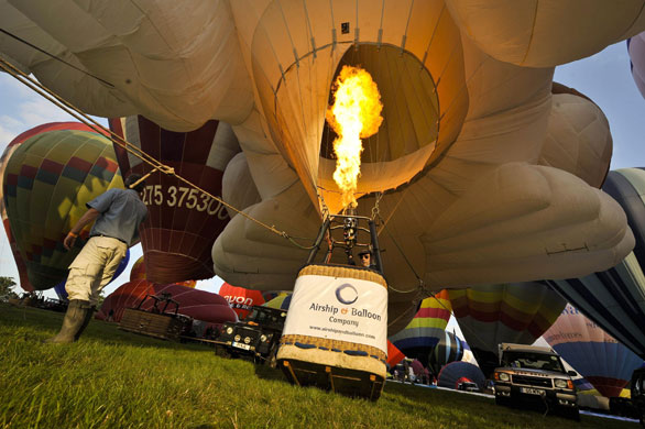 Bristol balloon festival: A hot air balloon pilot activates the burners on his balloon