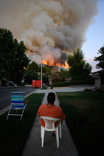 California wildfires: A man watches as a wall of flames from a backfire 
