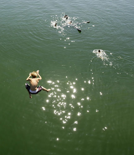 1 September 2009: Utting, Germany: A boy jumps into the cool water of the Ammersee lake