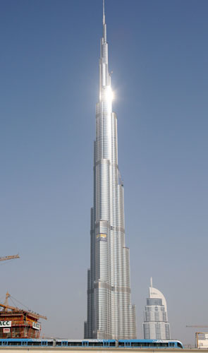 Dubai Metro: Dubai metro train speeds past the Worlds highest skyscraper Burj Dubai