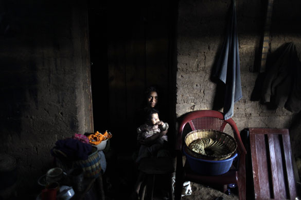 24 hours in pictures: Japala, central Guatemala: Josefa Ortega holds her brother Juan in San Yuyo