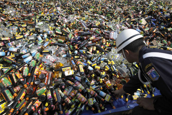 24 hours in pictures: Jakarta, Indonesia: Security officer checks bottles of alcohol confiscated