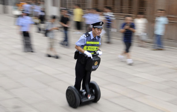 24 hours in pictures: A policeman uses a Segway to patrol a street in China