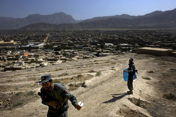 24 hours in pictures: Kabul, Afghanistan: An Afghan National Policeman prepares to fly a kite