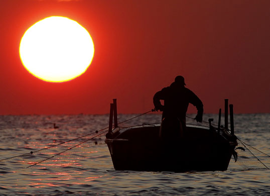 24 hours in pictures: Mathews, Virginia, US: A fisherman at sunrise over Chesapeake Bay 