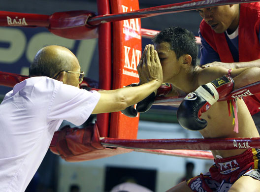 24 hours in pictures: Bangkok, Thailand: A Thai boxing fighter receives balm inhalation