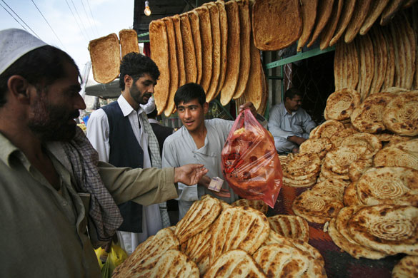 24hours : An Afghan man buys bread to break