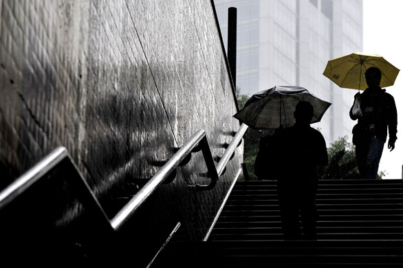 24 hours in pictures: Shanghai, China: Pedestrians enter a metro station heavy rain 