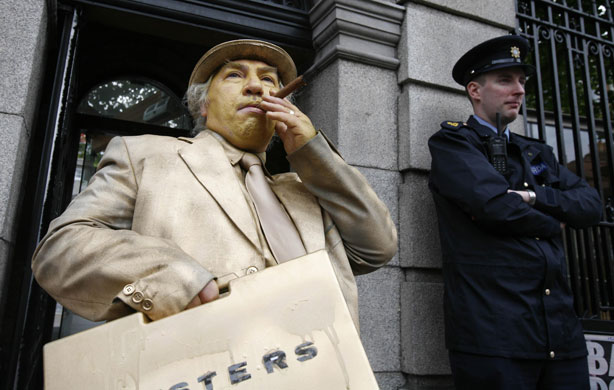Week in Business: A protester dressed as a banker stands outside Leinster House in Dublin