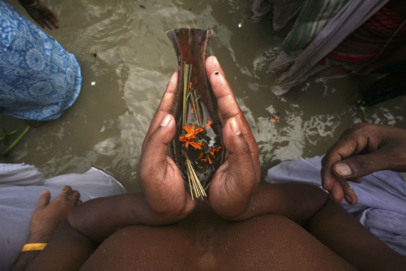 24 hours in pictures: Hindu man offers prayers on the banks of river Ganges in Kolkata