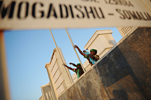 24 hours in pictures:  Ugandan soldiers under the AMISOM raise the flags of Burundi and Uganda