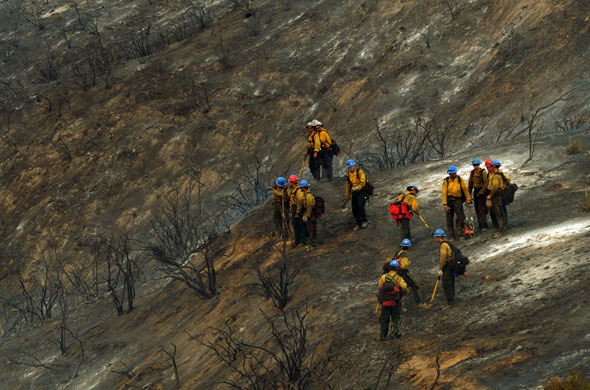 Wildfires California: Firefighters stand amongst burnt out brush during the Station Fire