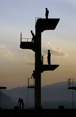 24 hours: Kabul, Afghanistan: Locals climb on the diving board of an unfinished pool 