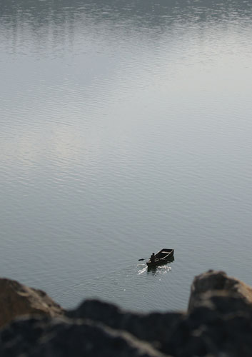 24 hours: A Kosovan fisherman rows his boat at Lake Vermica