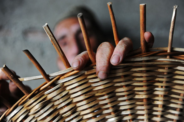 24 hours: A Kashmiri craftsman works on a wicker product in Srinagar