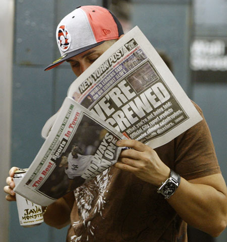 Climate Week in New York: A man reads a fake edition of the New York Post on a subway platform