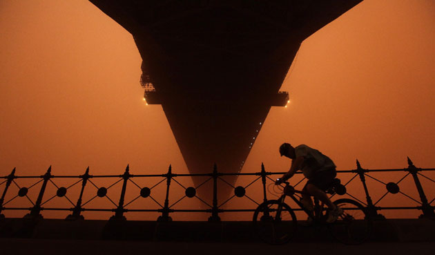 Sydney dust storm: A cyclist rides under the Sydney Harbour bridge