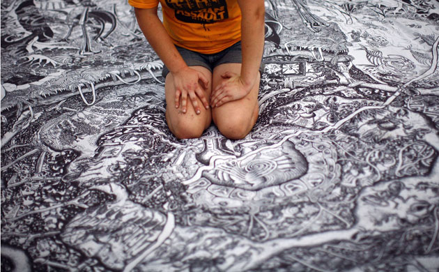 Protest G20 Pittsburgh: A demonstrator kneels on a tapestry outside a rally 
