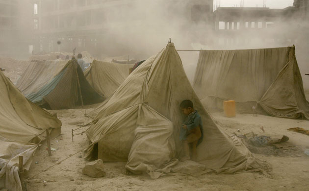Dust storm: Afghan refugee child hides from a dust storm 