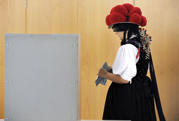 24 hours in pictures: Gutach, Germany: A woman wearing traditional costume casts her ballot