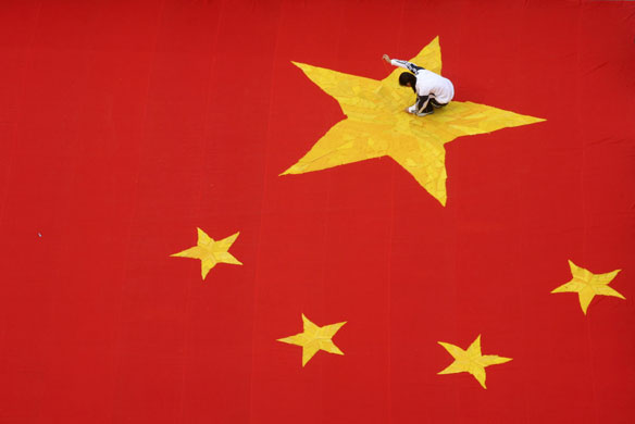 24 hours in pictures: Jinan, Shandong province, China: A student embroiders a star on a flag