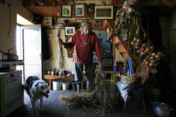 24 hours in pictures: Clare Island, Ireland: Farmer Bernie Winter holds straw to make a basket 
