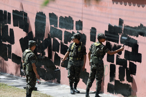 Honduras crisis: Soldiers paint over graffiti on the walls around the Brazilian Embassy